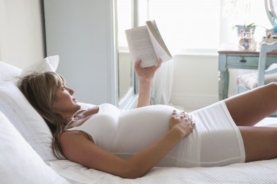 אישה בהריון קוראת ספר